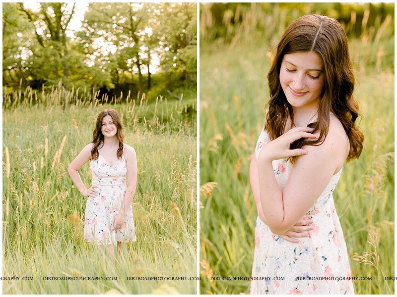 senior picture of girl standing in tall prarie grass with trees at sunset. senior girl wearing floral sun dress with dark brown long curly hair. picture taken near western, nebraska. omaha senior pictures. nebraska senior photographer located near lincoln, nebraska.