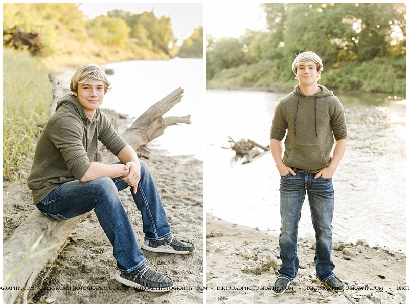 senior picture of boy wearing jeans and a green hoodie standing near river front at sunset. senior standing on bank of river sitting by wood log with blond hair. blue river senior picture. filley stone. beatrice nebraska senior pics. nebraska senior photographer located near lincoln, nebraska.