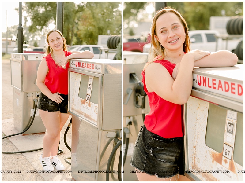 senior picture of girl with brown long hair and wearing a bandana and red tank top with black jean shorts and adidas tennis shoes. senior girl is standing by old gas pump with sunflare shining on her. hastings high school. nebraska senior photographer located near lincoln, nebraska.