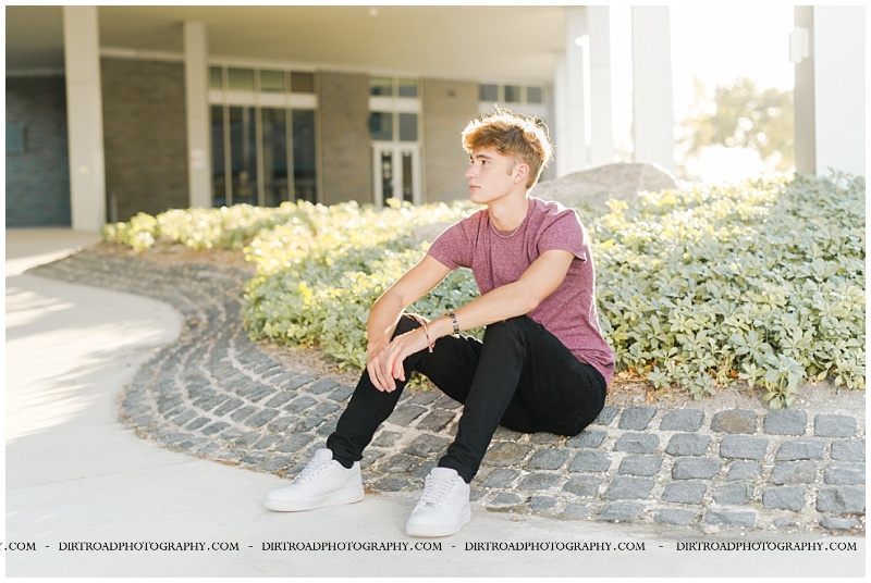 Dylan, a senior from Lincoln, Nebraska. He is wearing a maroon shirt and black torn up jeggings. Senior pictures of boy in downtown haymarket lincoln nebraska near the haymarket park area. Nebraska senior photographer, Kelsey Homolka.