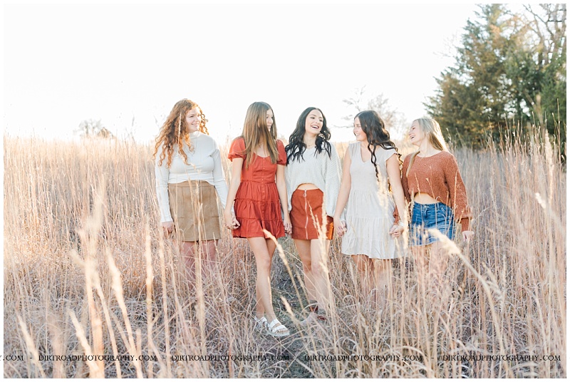 Fall senior rep pictures of girls. Senior girls wearing neutral fall colors standing in tall brown grass at sunset near Crete, Nebraska. Nebraska senior photographer Kelsey Homolka.