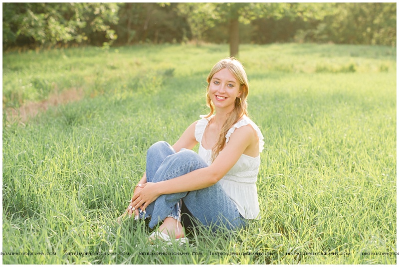 Nina in White Dress Among Yellow Flowers: A captivating portrait of Nina celebrating her senior year. She stands gracefully in a white dress amidst a vibrant field of wild yellow flowers, radiating joy and excitement under the warm Nebraska sun. The perfect blend of elegance and nature.